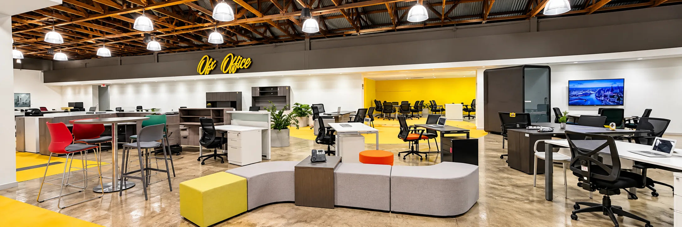 Showroom floor with workstations, curved lounge seating and the OFX Office sign