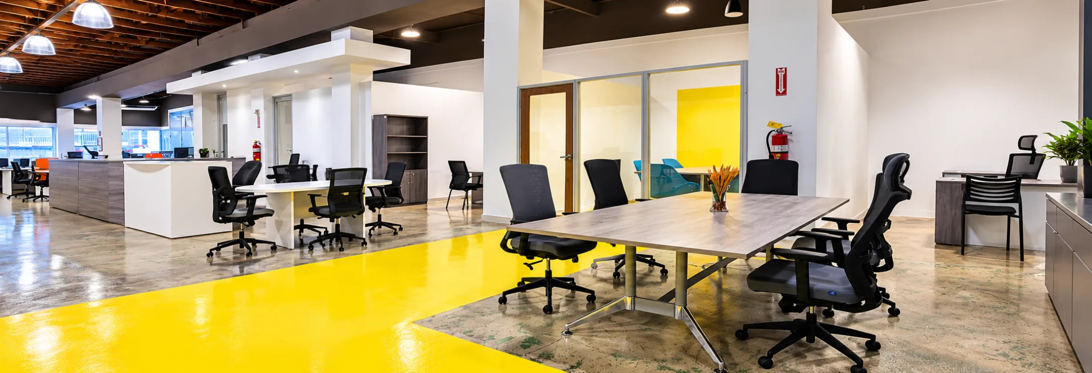 Meeting table and task chairs on the showroom's yellow floor