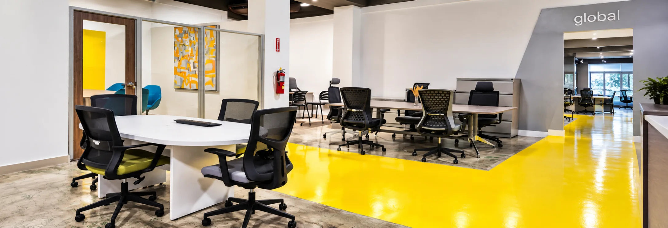 Round meeting table with task chairs beside the workstation displays