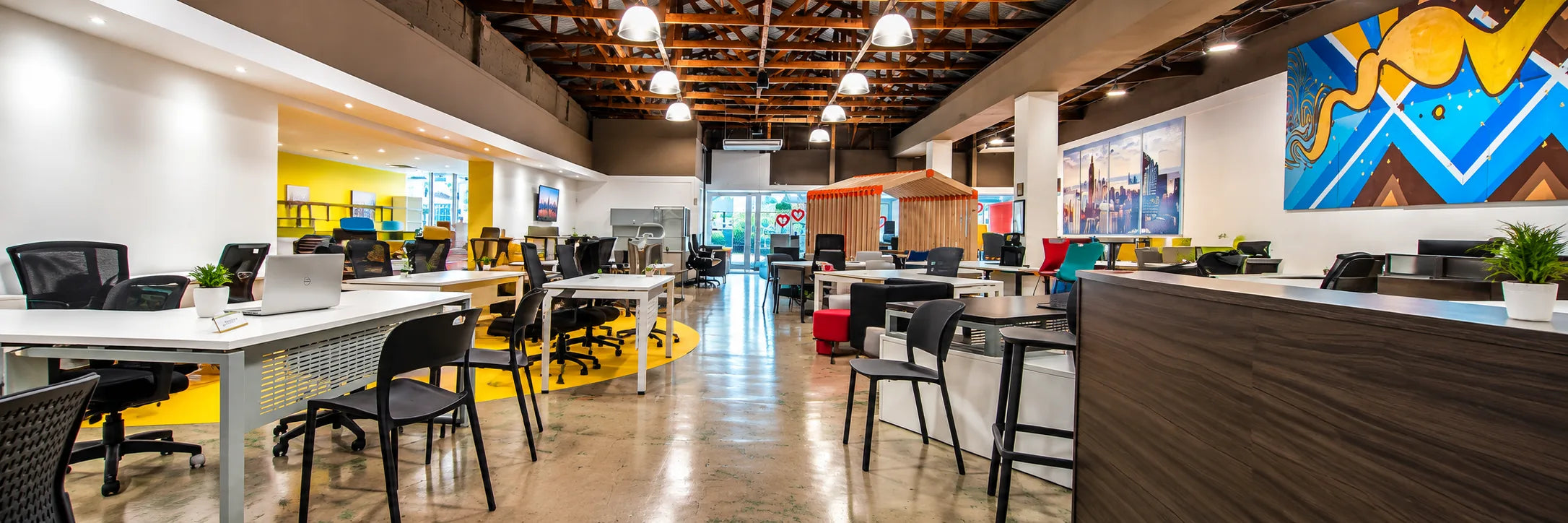 Showroom floor with workstations, mural wall and the reception counter